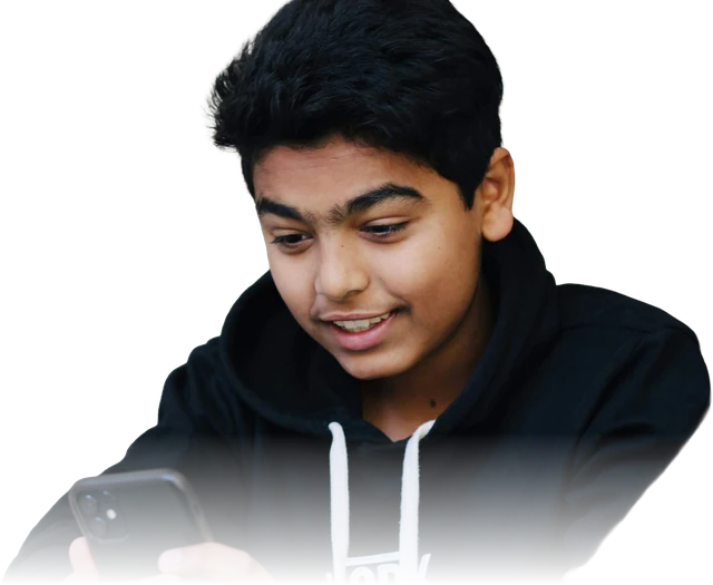 A smiling student looking at a phone